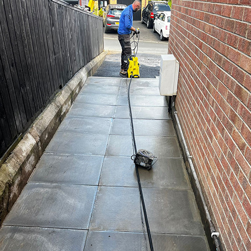 Worker actively cleaning path in Belfast area